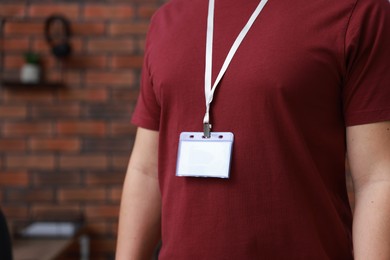 Photo of Man with blank badge in office, closeup