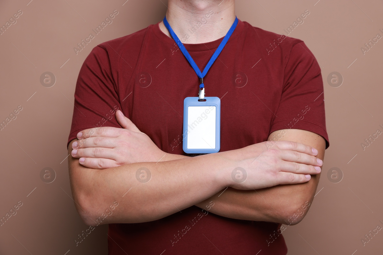 Photo of Man with blank badge on brown background, closeup