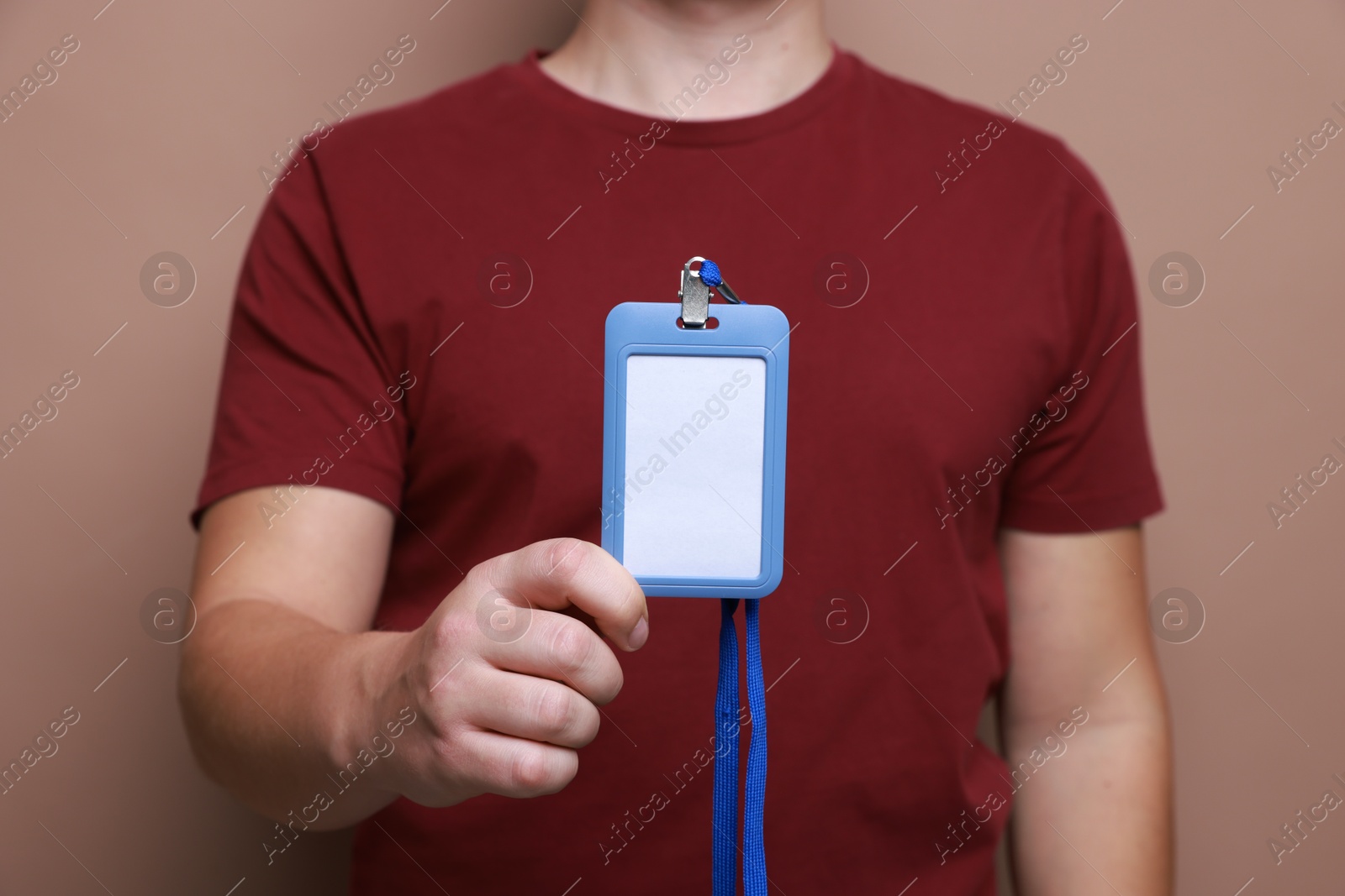 Photo of Man with blank badge on brown background, closeup