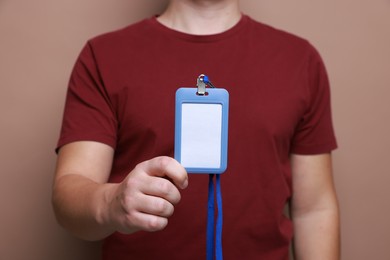 Photo of Man with blank badge on brown background, closeup