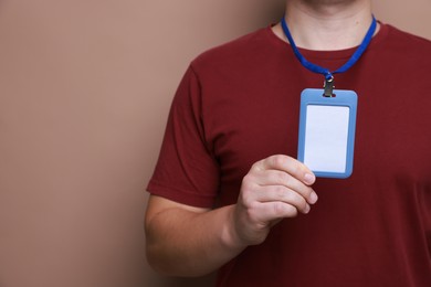 Photo of Man with blank badge on brown background, closeup. Space for text