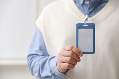 Photo of Man with blank badge indoors, closeup. Space for text