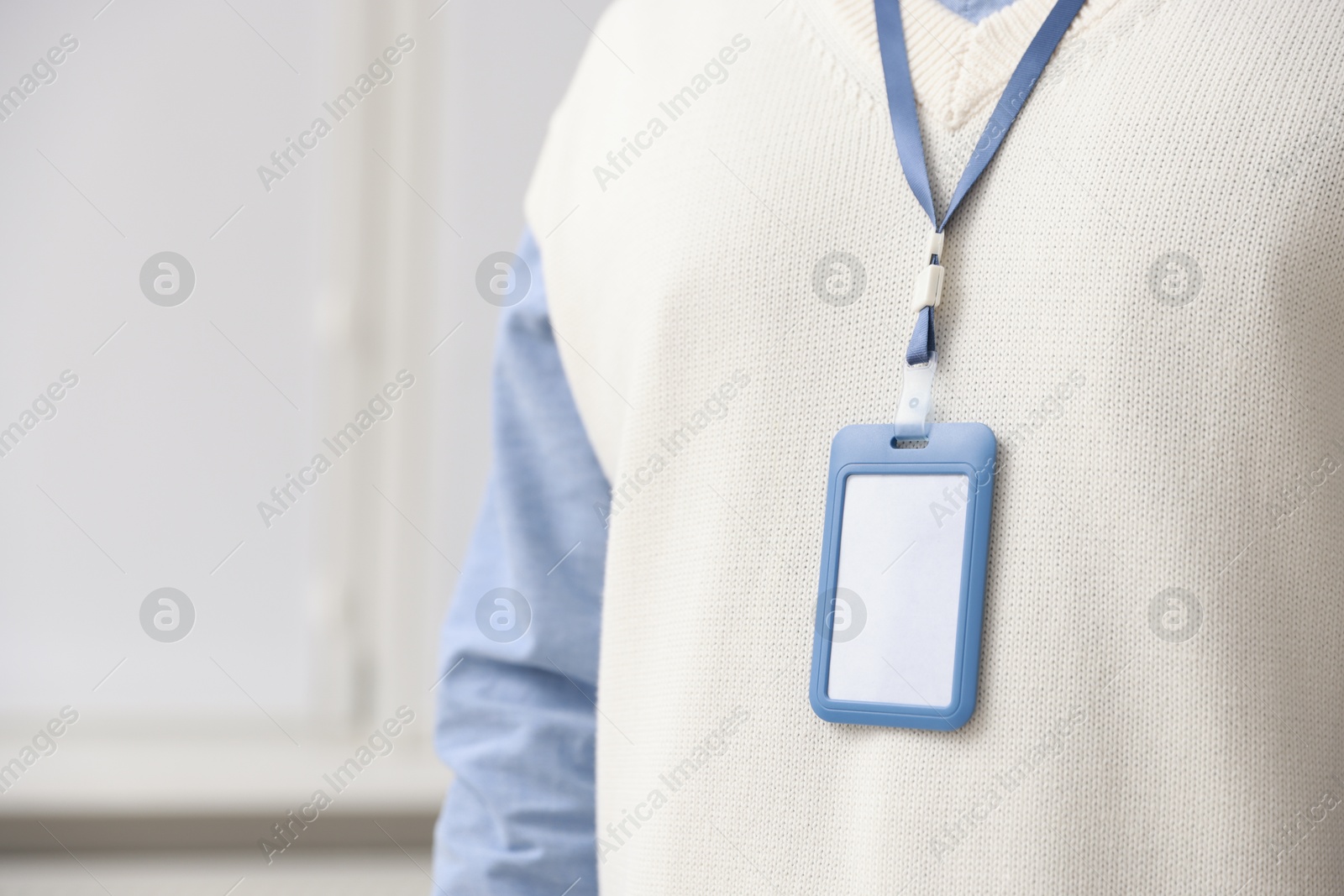 Photo of Man with blank badge indoors, closeup. Space for text