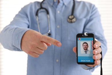 Photo of Doctor pointing at his badge in hospital, closeup