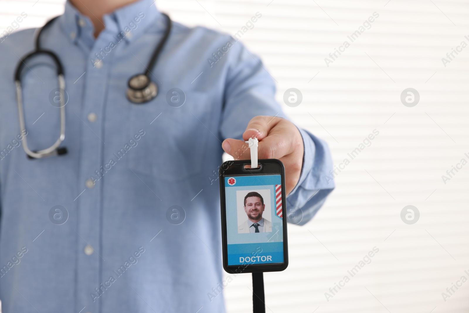 Photo of Doctor with badge in hospital, closeup. Space for text