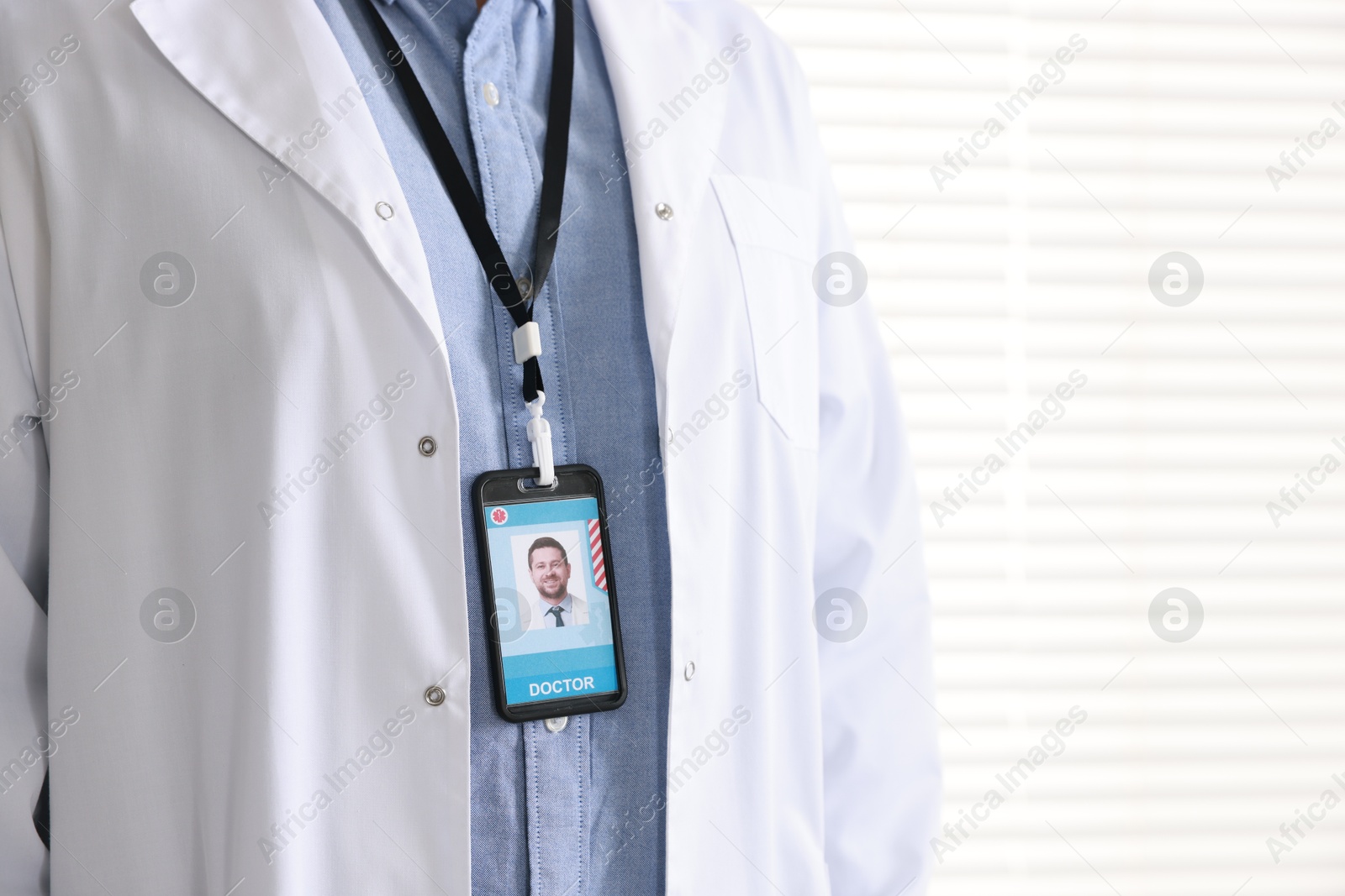 Photo of Doctor with badge in hospital, closeup. Space for text