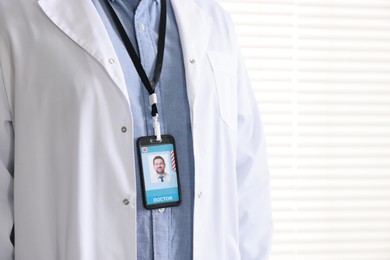 Photo of Doctor with badge in hospital, closeup. Space for text