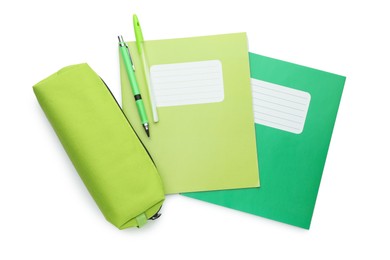 Photo of Copybooks, pencil case and pens on white background, top view