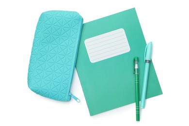 Photo of Copybook, pencil case and pens on white background, top view