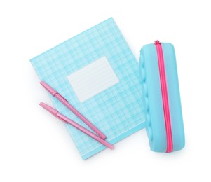 Photo of Copybook, pencil case and pens on white background, top view