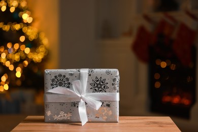 Photo of Christmas gift box on wooden table indoors, space for text