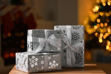 Photo of Christmas gift boxes on wooden table indoors