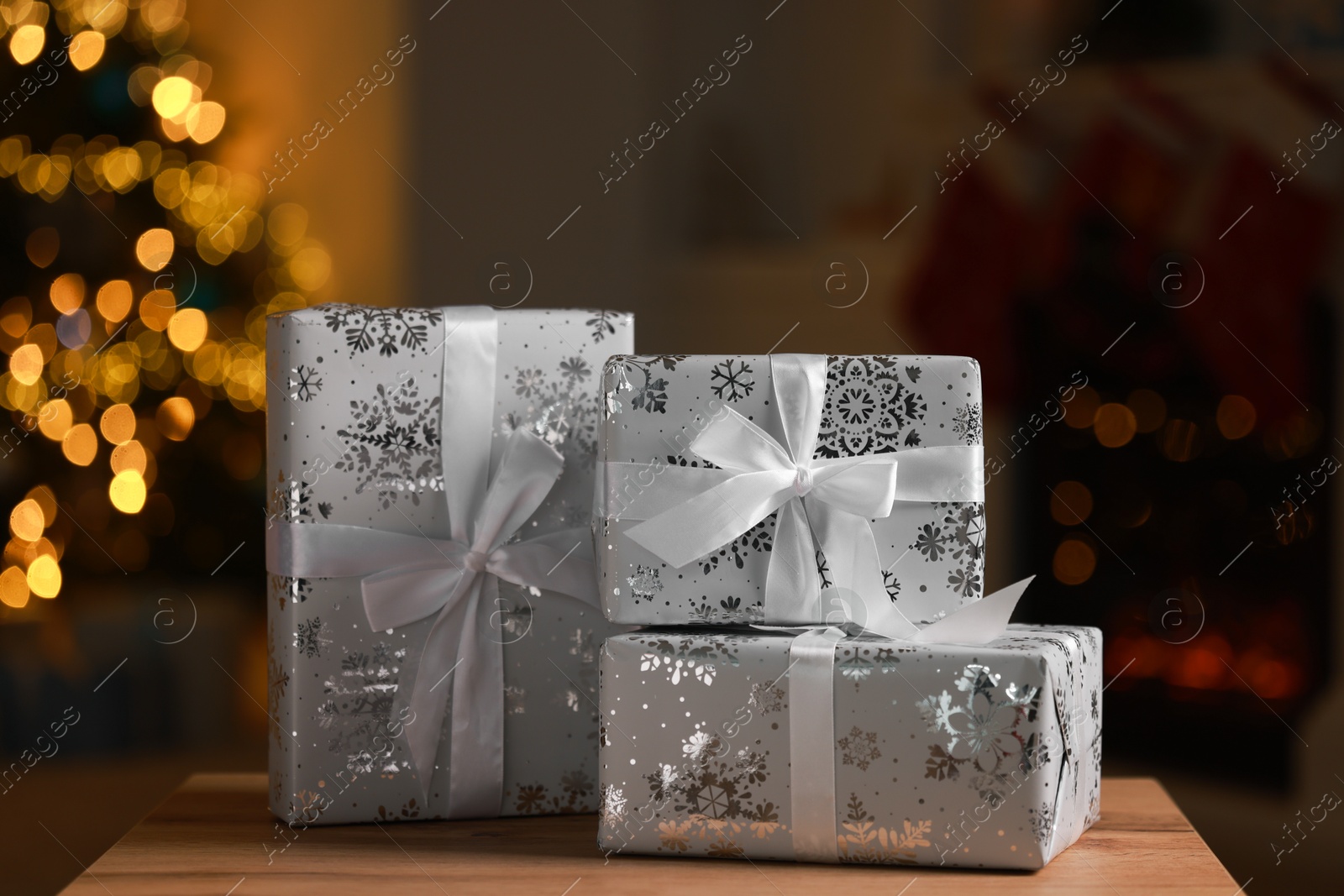 Photo of Christmas gift boxes on wooden table indoors