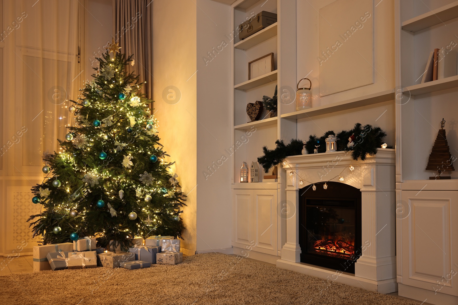 Photo of Christmas tree and decorated fireplace in room. Festive interior