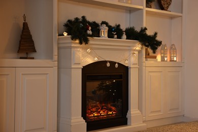 Photo of Fireplace with garland and other Christmas decor indoors