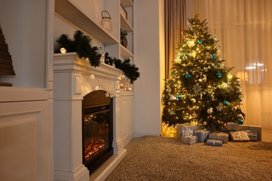 Photo of Christmas tree and decorated fireplace in room. Festive interior