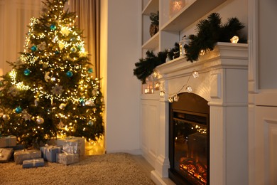 Photo of Decorated fireplace and Christmas tree in room. Festive interior