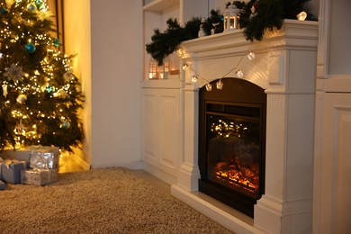 Photo of Decorated fireplace and Christmas tree in room. Festive interior