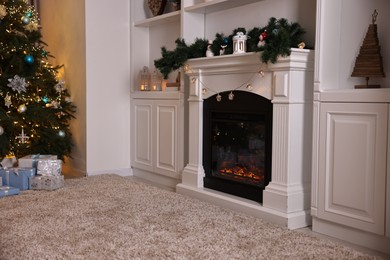 Photo of Decorated fireplace and Christmas tree in room. Festive interior