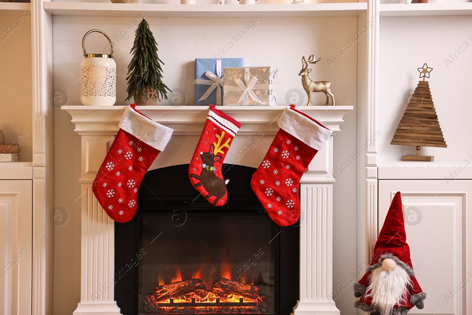 Photo of Fireplace with stockings and Christmas decor indoors