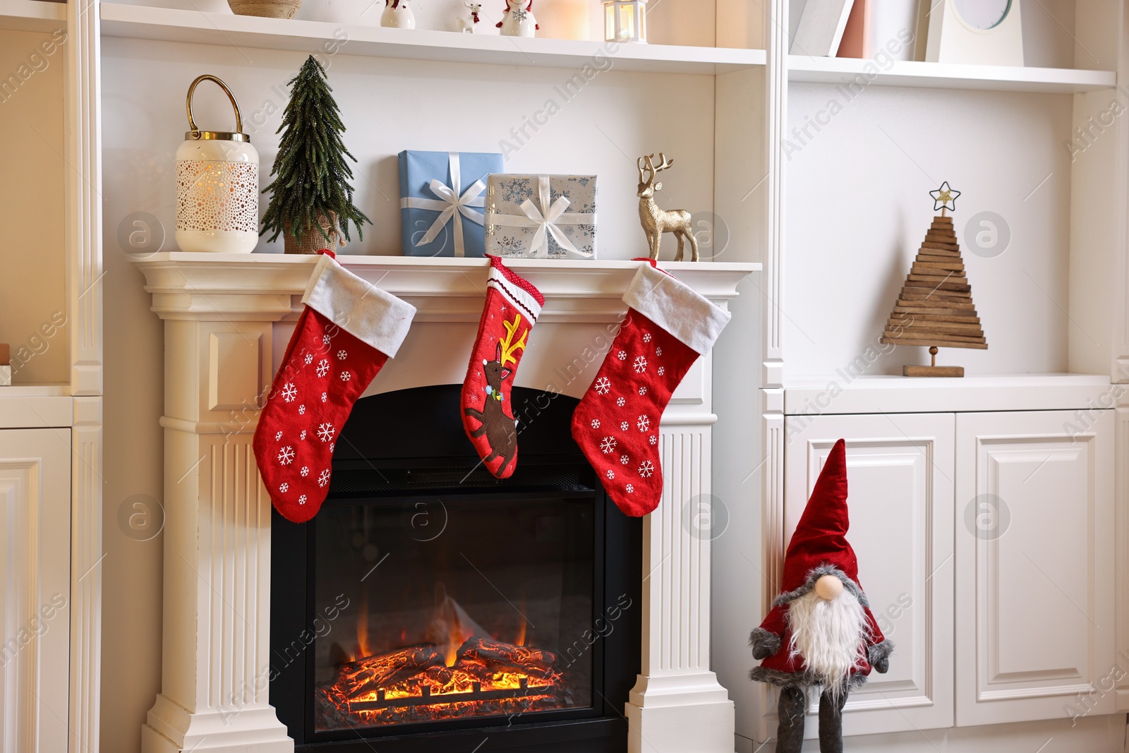 Photo of Fireplace with stockings and Christmas decor indoors