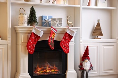 Photo of Fireplace with stockings and Christmas decor indoors