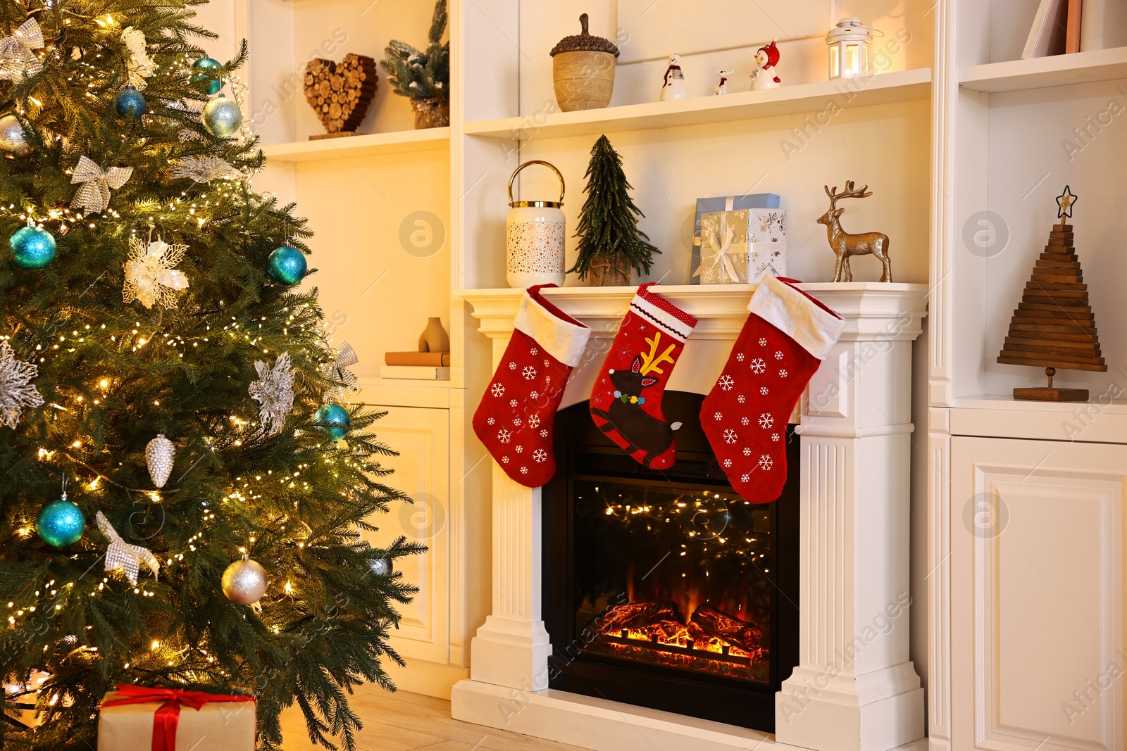 Photo of Christmas tree and decorated fireplace in room. Festive interior