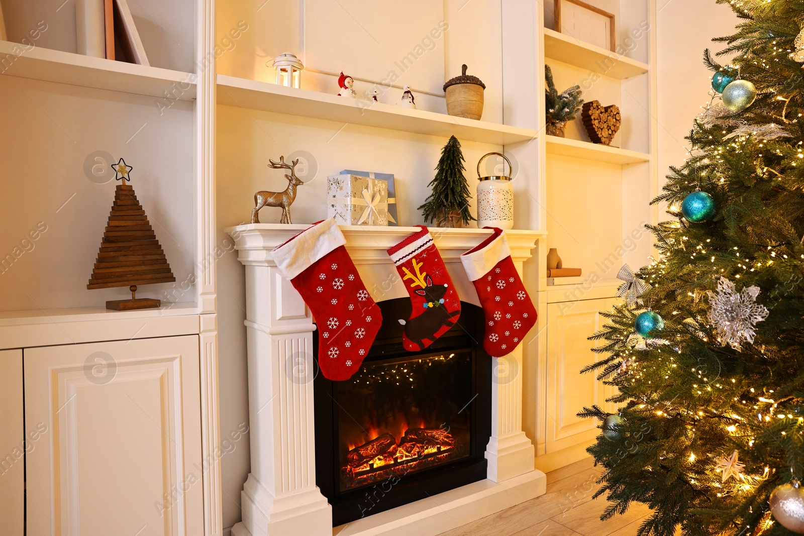 Photo of Fireplace with stockings and Christmas tree indoors