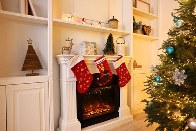 Photo of Fireplace with stockings and Christmas tree indoors