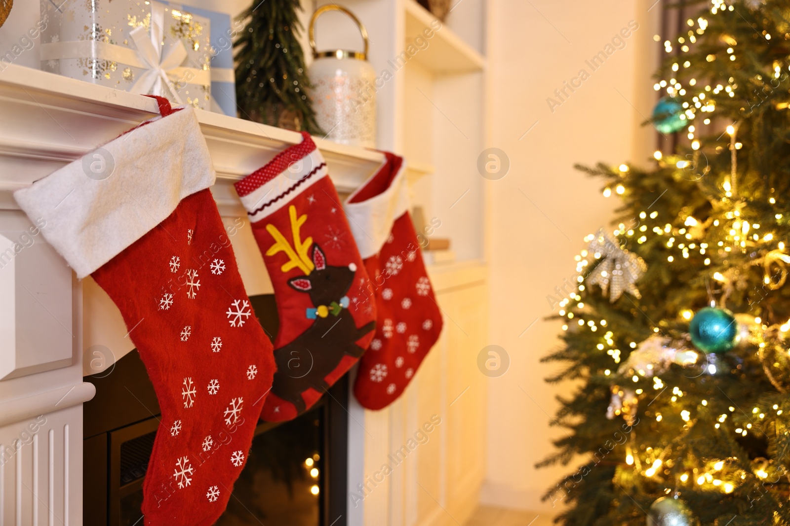 Photo of Fireplace with stockings and Christmas tree indoors