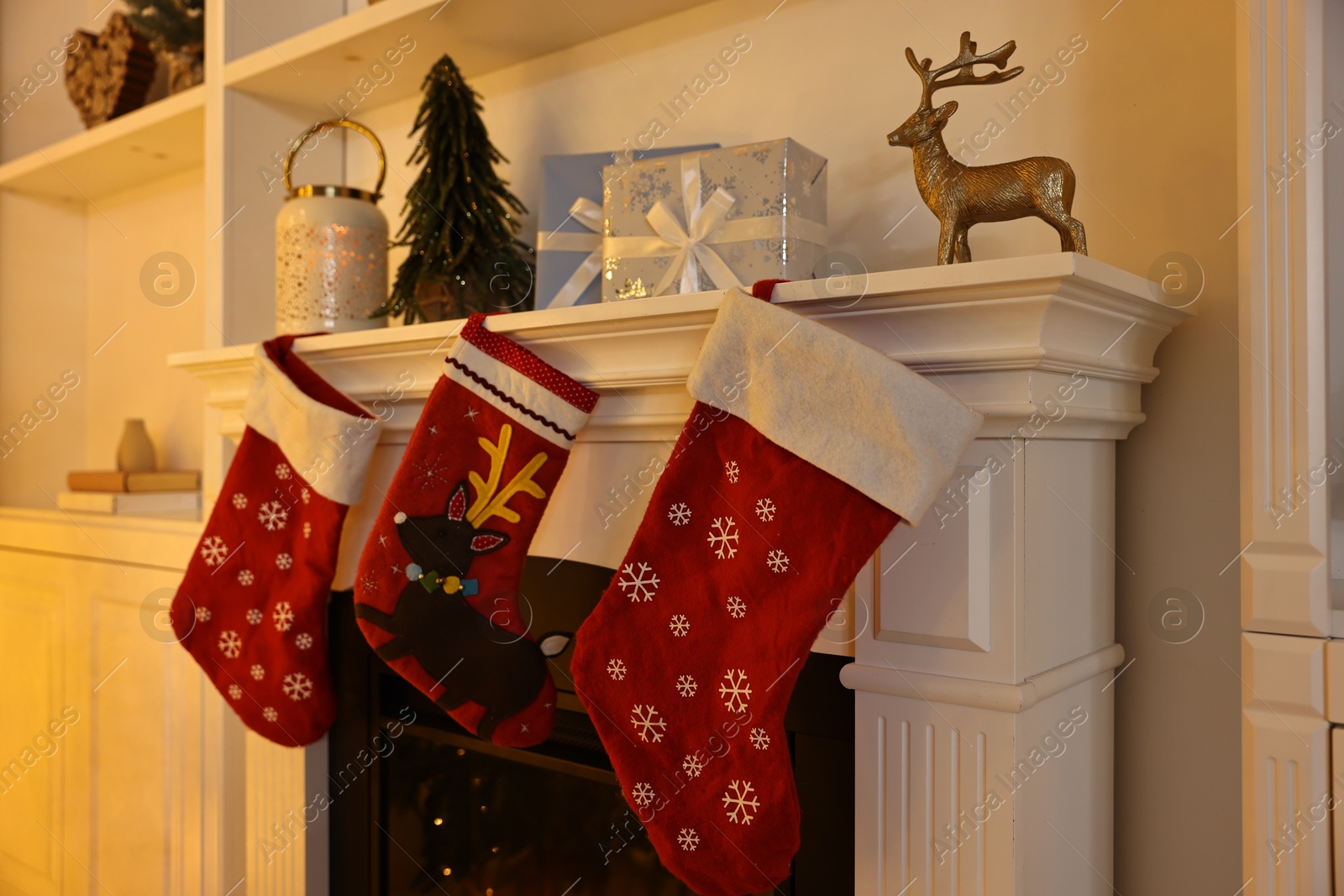 Photo of Fireplace with stockings and Christmas decor indoors