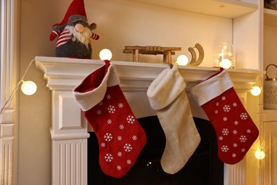 Photo of Fireplace with stockings and Christmas decor indoors