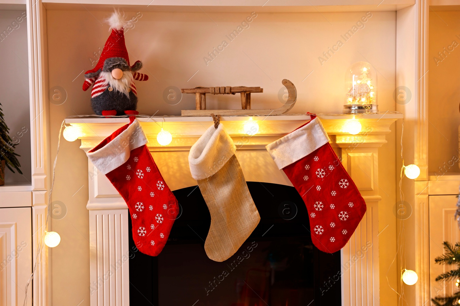 Photo of Fireplace with stockings and Christmas decor indoors