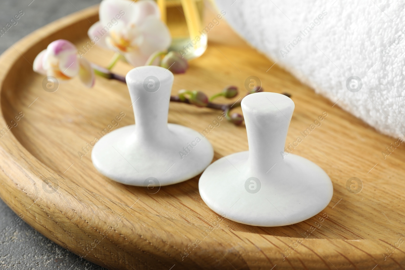 Photo of Spa stones, orchid branch and towel on table, closeup