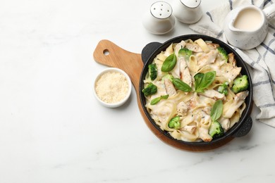 Photo of Delicious pasta Alfredo with chicken served on white marble table, flat lay. Space for text