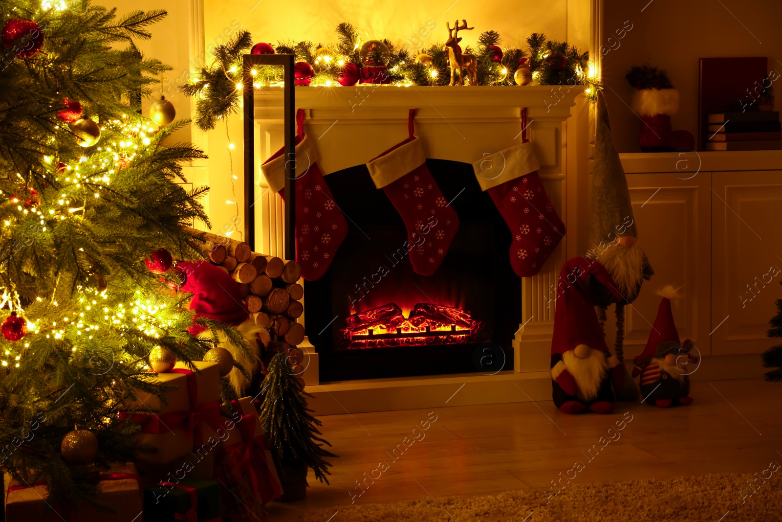 Photo of Stylish fireplace, Christmas tree with festive decor and presents indoors