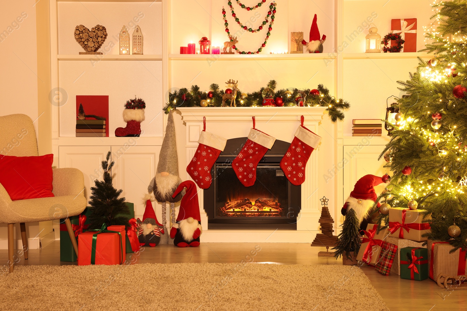 Photo of Stylish fireplace, Christmas tree with festive decor and presents indoors