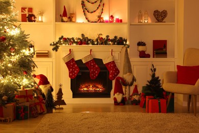 Photo of Stylish fireplace, Christmas tree with festive decor and presents indoors