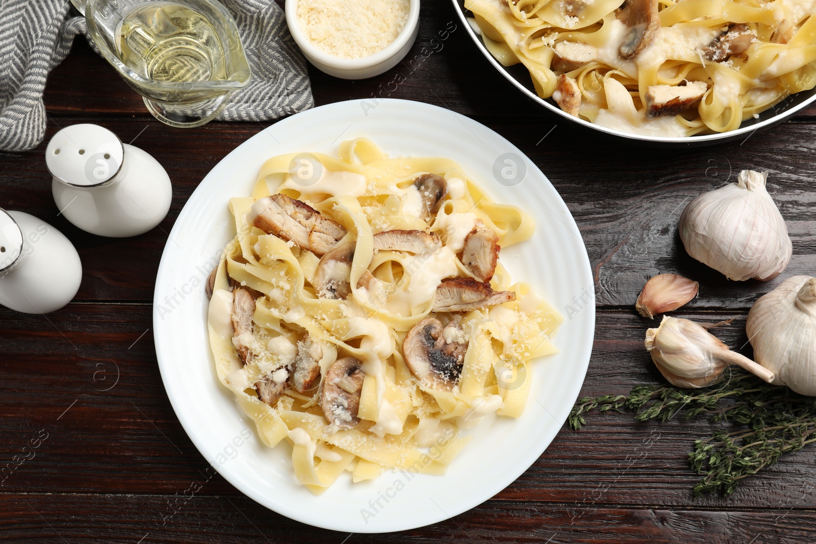 Photo of Flat lay composition with tasty Alfredo pasta with chicken and mushrooms on wooden table