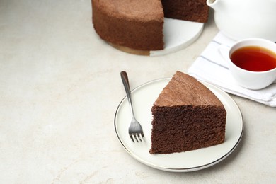 Photo of Piece of tasty chocolate sponge cake served on light table. Space for text