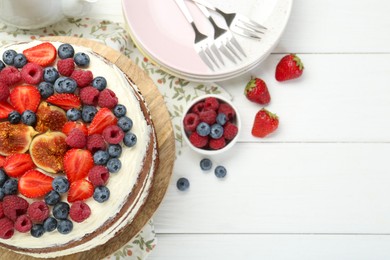 Photo of Delicious chocolate sponge cake with berries served on white wooden table, top view. Space for text