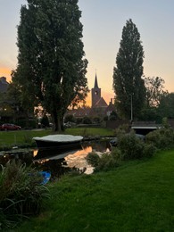 Photo of Picturesque view of canal with moored boats on sunset