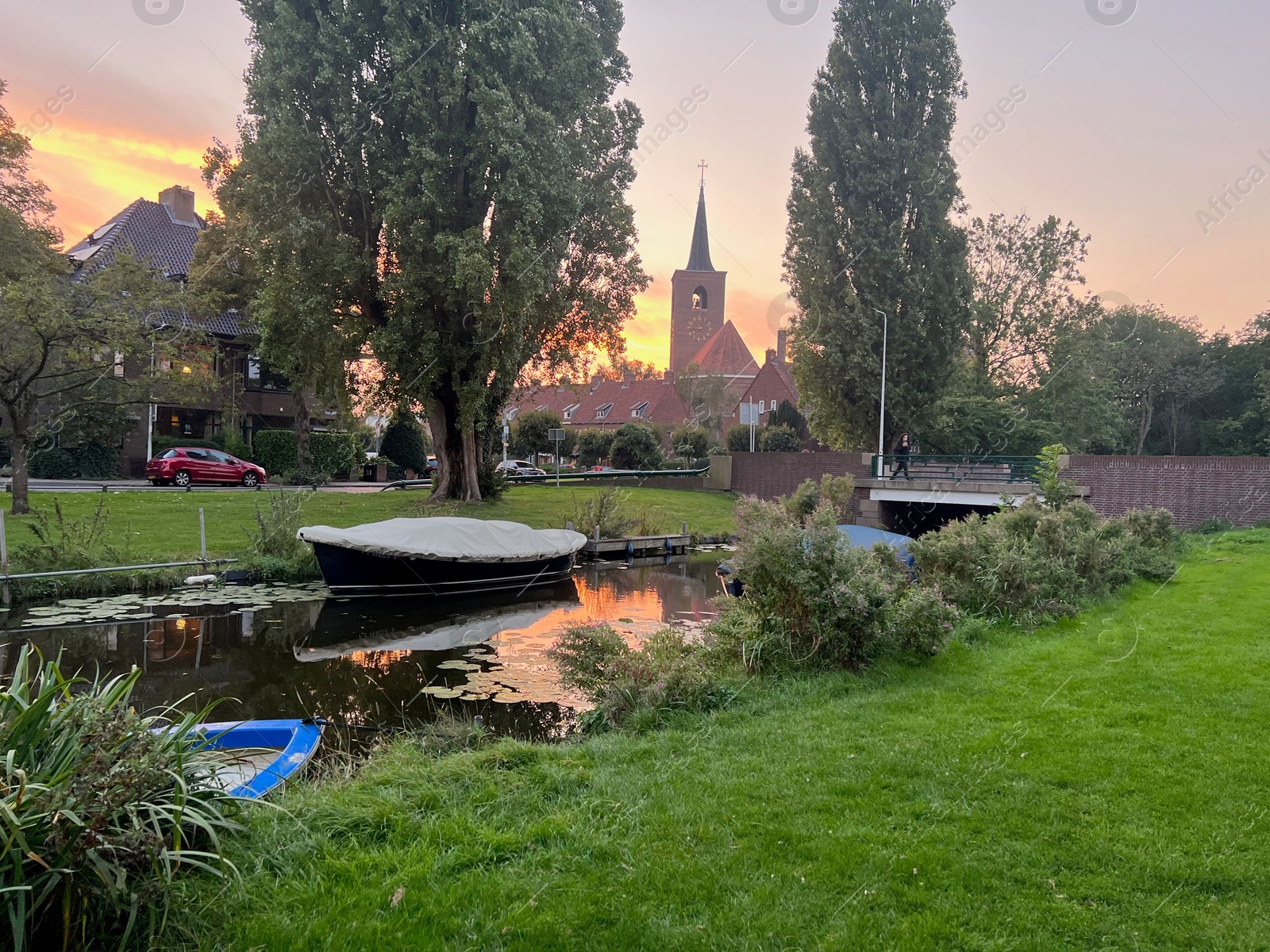 Photo of Picturesque view of canal with moored boats on sunset