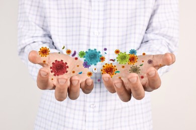 Image of Man showing hands with microbes on white background, closeup. Illustration of microorganisms