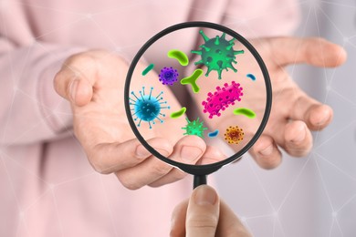 Image of Woman looking at man's hand with magnifying glass, closeup. Illustration of microbes