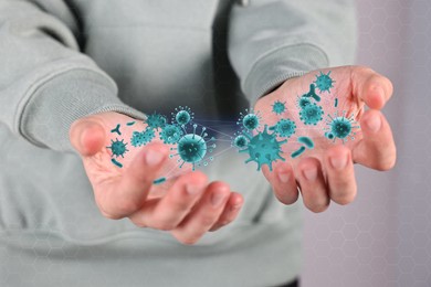 Image of Man showing hands with microbes on grey background, closeup. Illustration of microorganisms