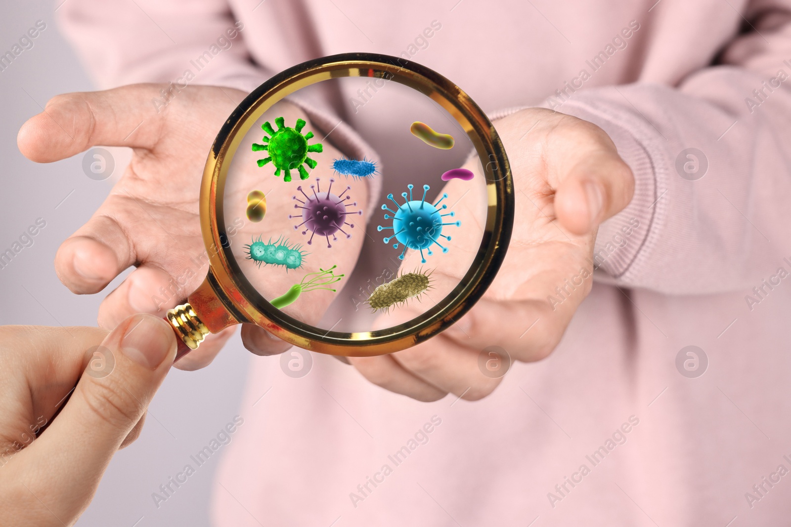 Image of Woman looking at man's hand with magnifying glass, closeup. Illustration of microbes