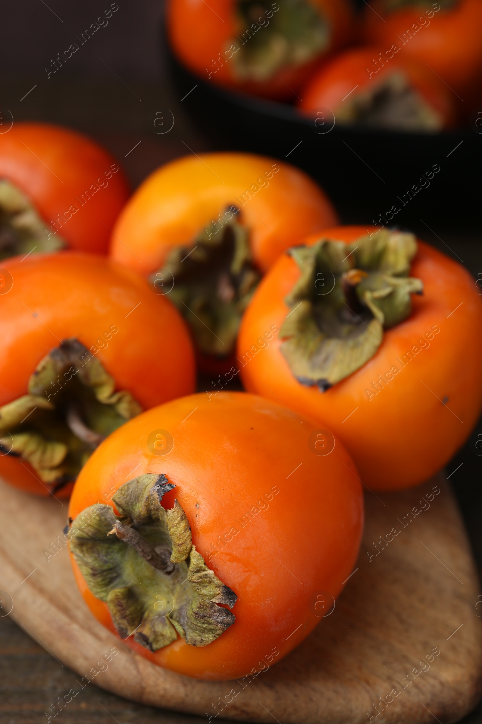 Photo of Delicious fresh juicy persimmons on wooden table, closeup