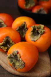 Delicious fresh juicy persimmons on wooden table, closeup