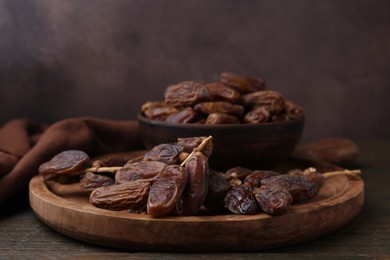 Photo of Tasty dried dates on wooden table, closeup